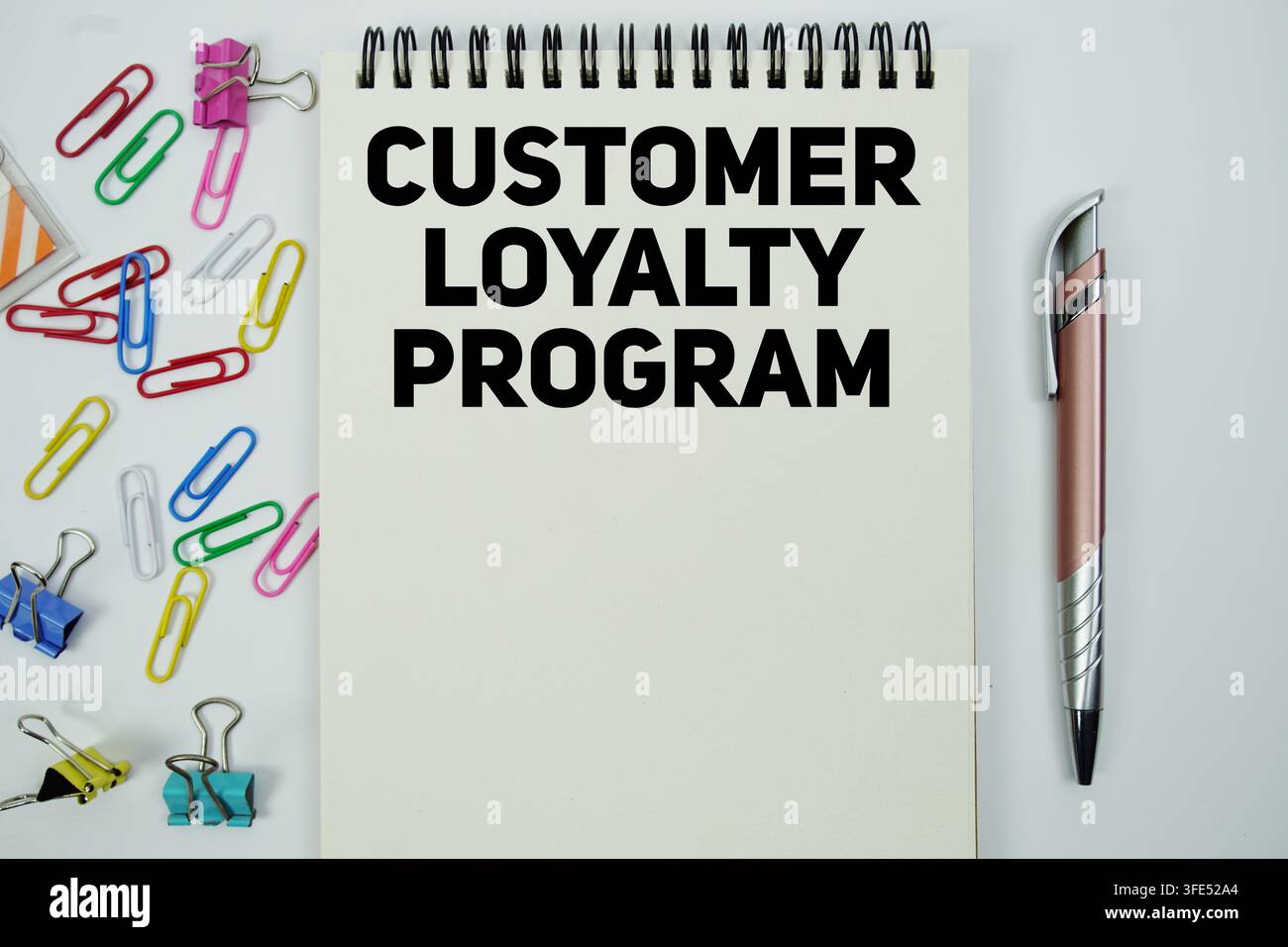 Customer Loyalty Program text message written on notepad with stationery flat lay on white background Stock Photo