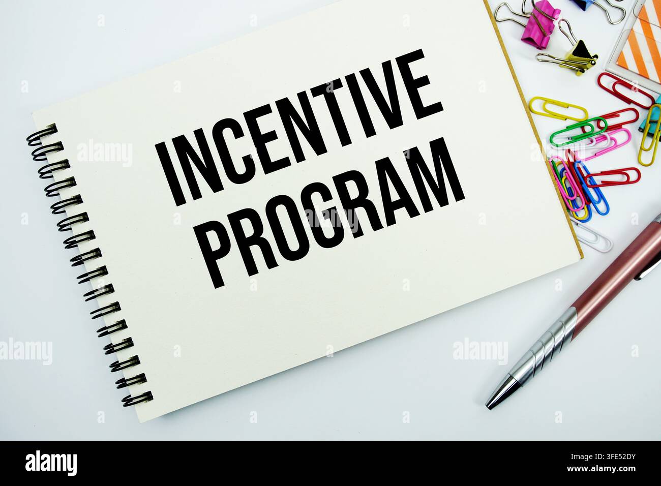 Incentive program text message written on notepad with stationery flat lay on white background Stock Photo