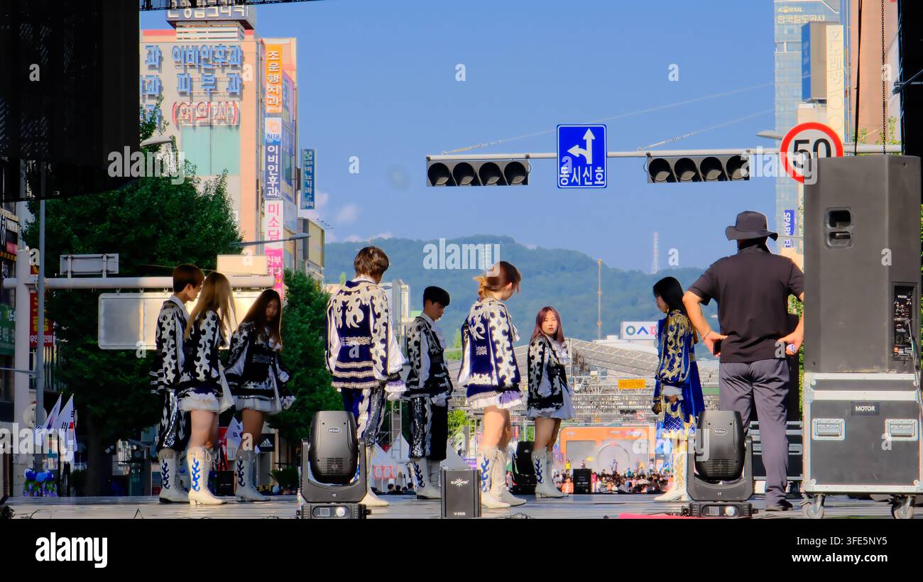 Group of Korean cultural performers in traditional attire preparing for a parade on a city street in Korea. Stock Photo
