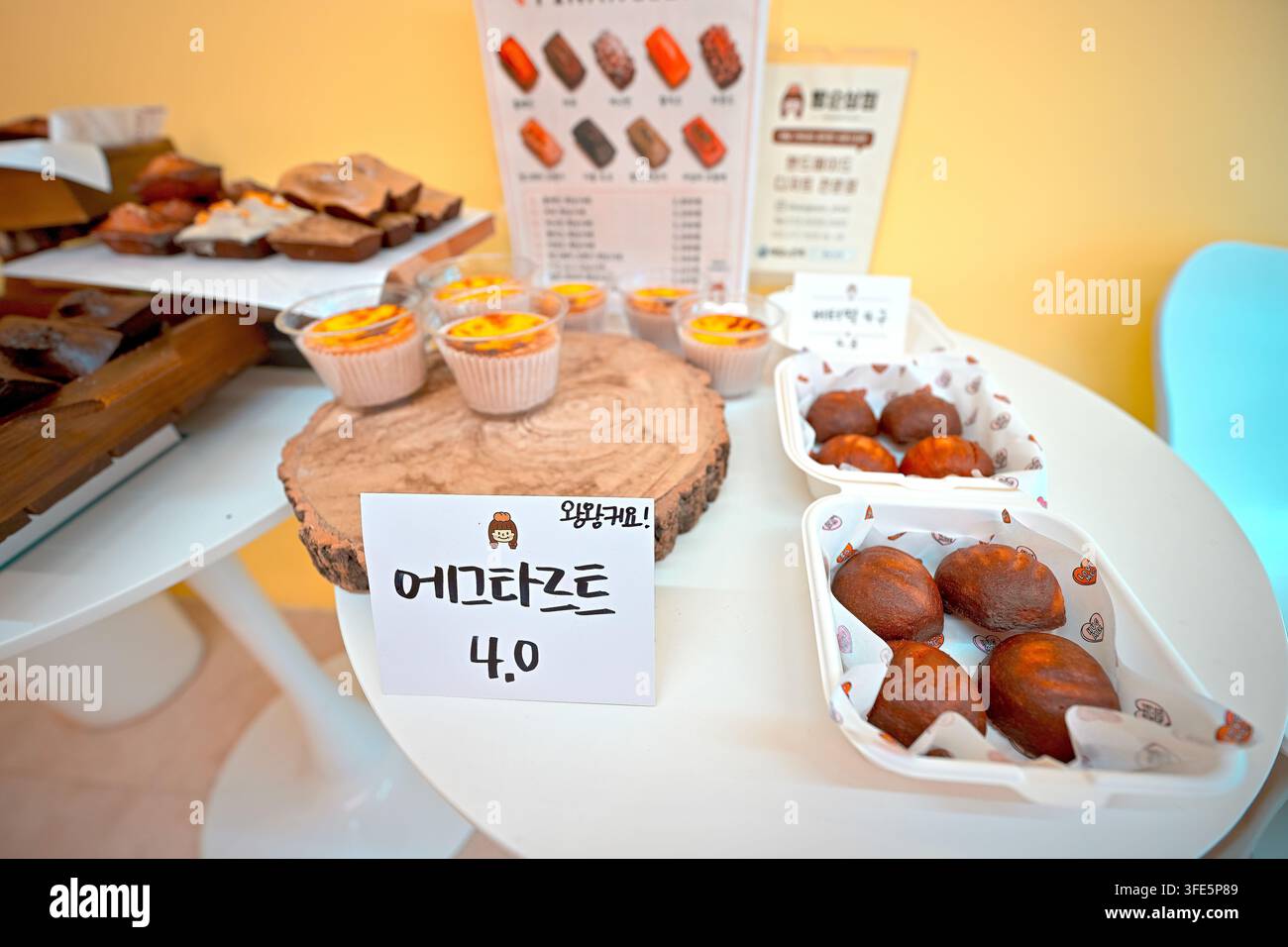 Assorted Korean bakery items including egg tarts and bread displayed on a table in Korea. Stock Photo