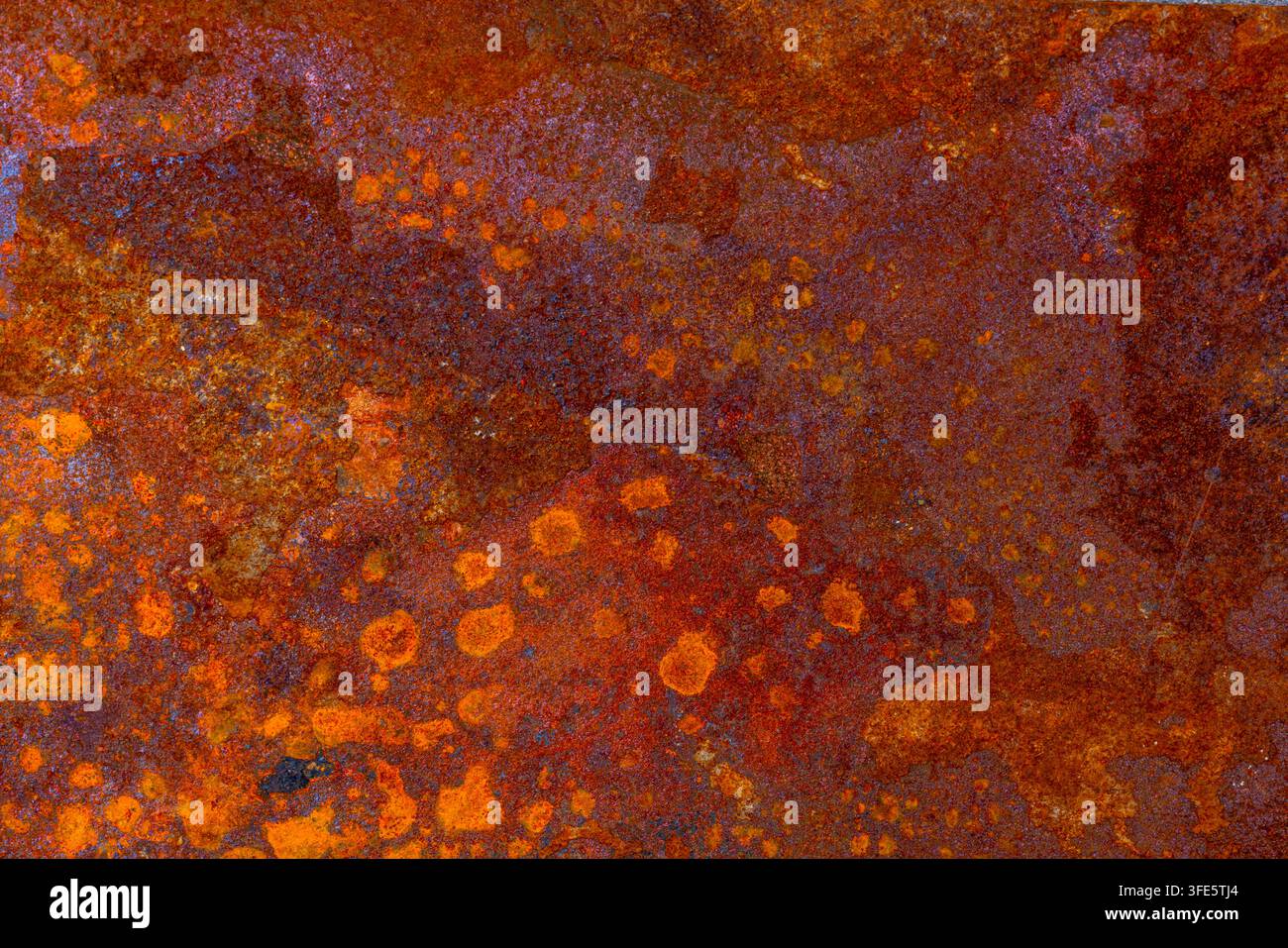 Abstract background image featuring a close-up of heavily rusted metal. Rich oxidized colors and rough texture create an organic, weathered appearance Stock Photo