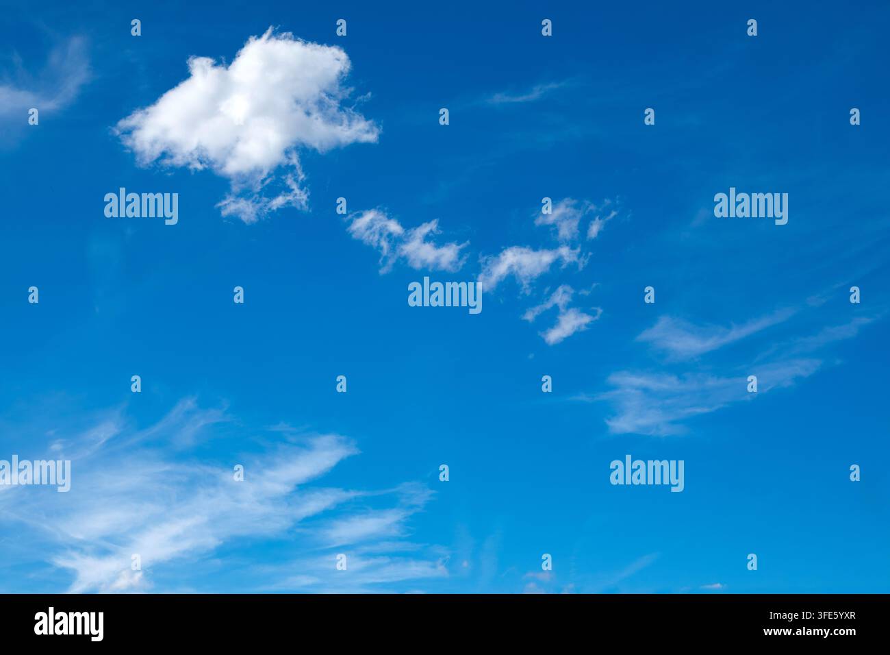 Sky background with fluffy white clouds on a bright blue sky Stock Photo