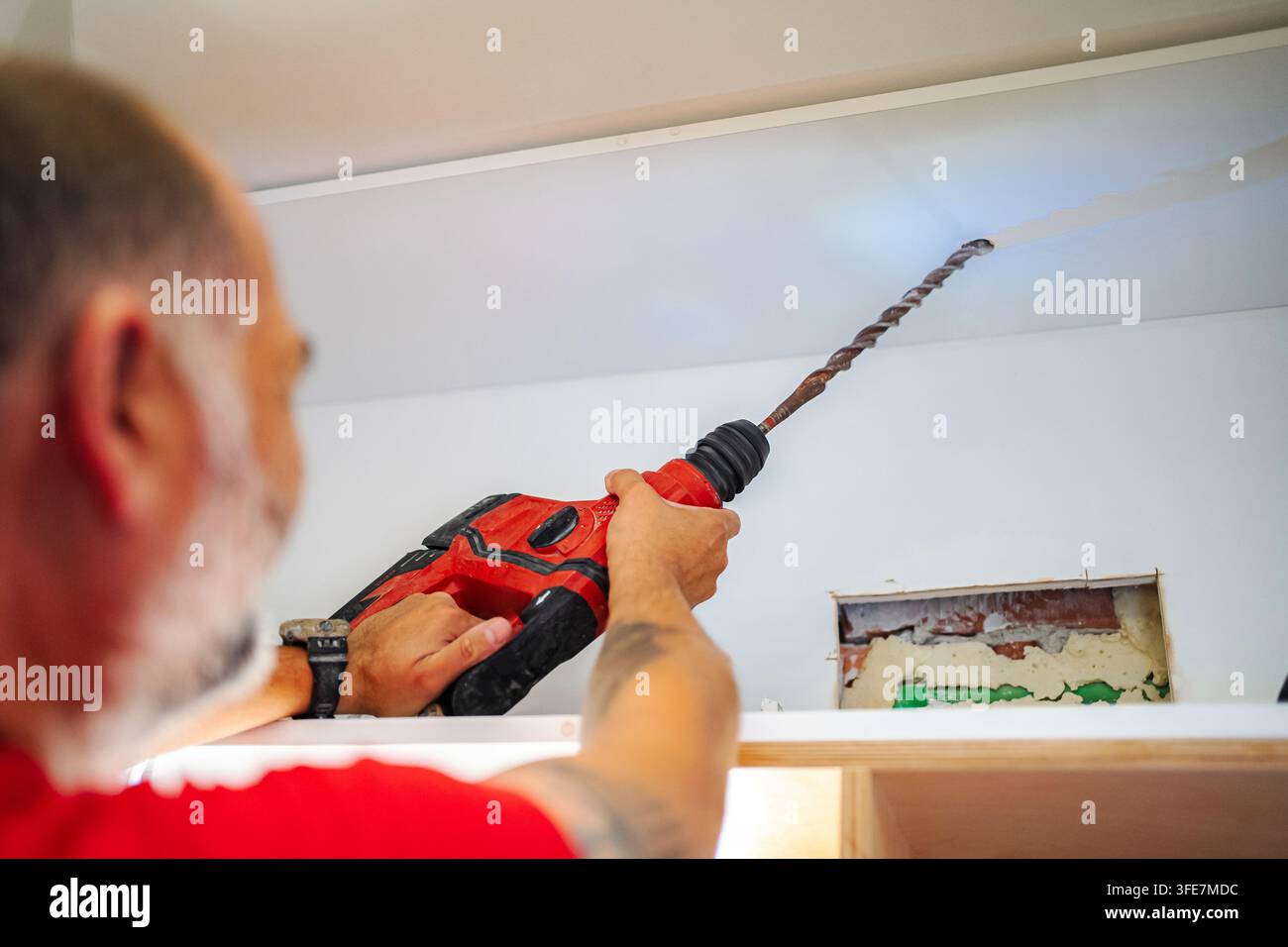Man using hammer drill tool for home renovation project Stock Photo