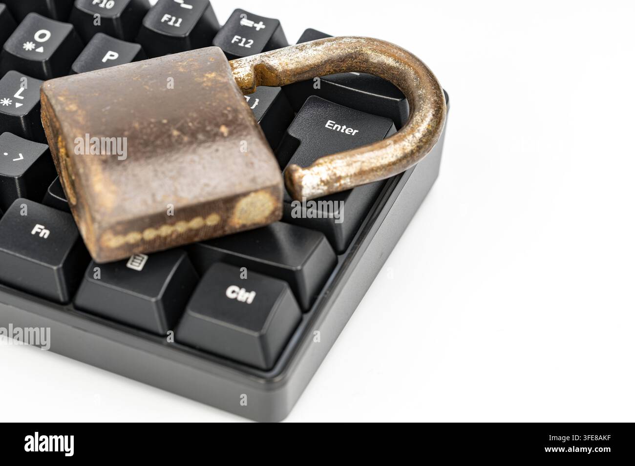 Rusty unlocked padlock on a computer keyboard near enter key, symbolizing cybersecurity and online data risks. Stock Photo