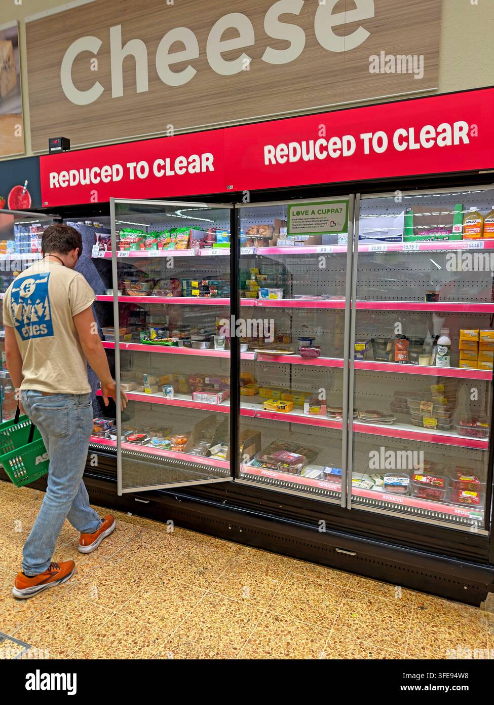 Asda supermarket shopper browses discounted short-dated food, reflecting cost-of-living pressures and efforts to cut food waste. Stock Photo