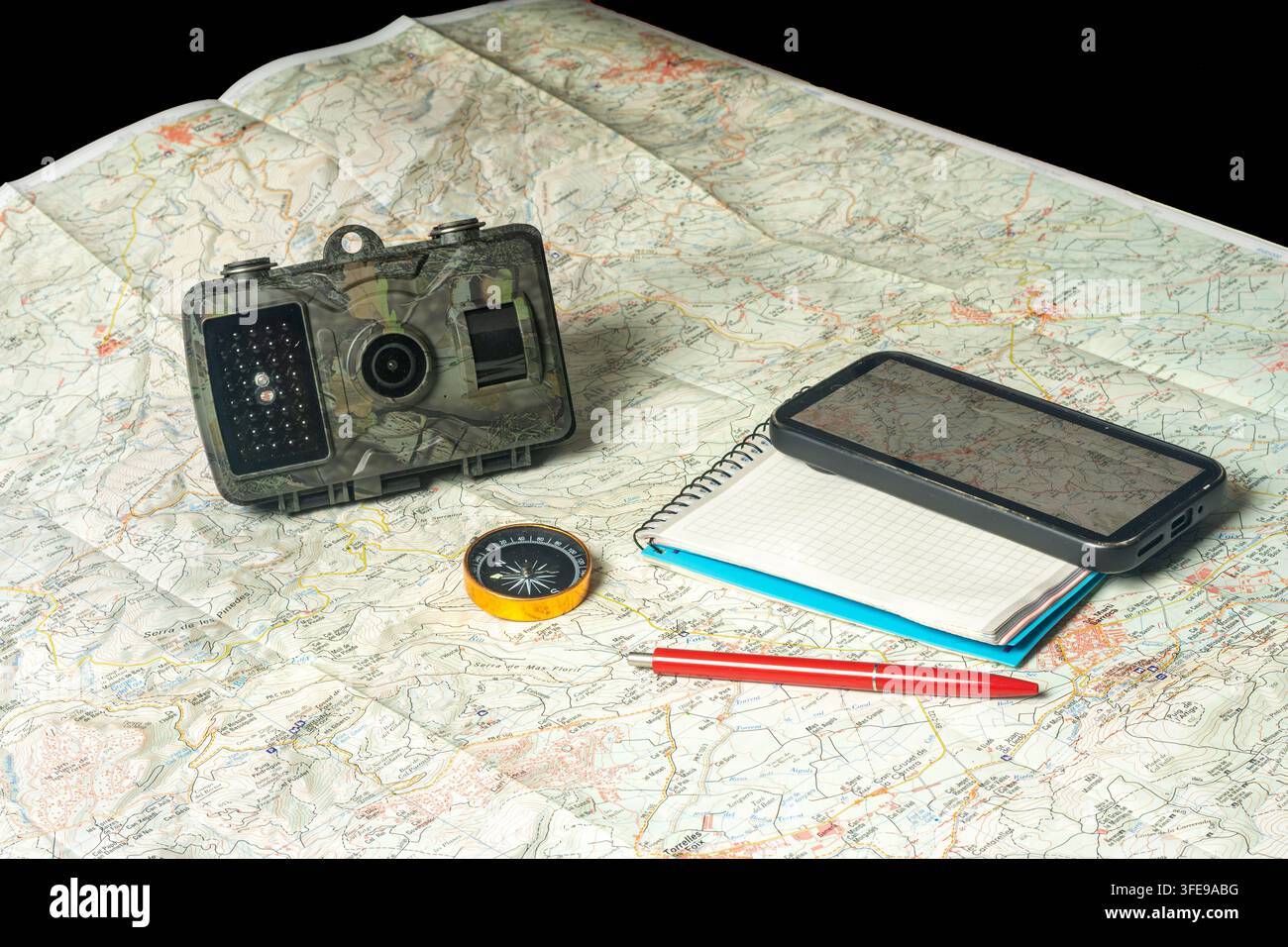 Wildlife trail camera with navigation tools on map Stock Photo