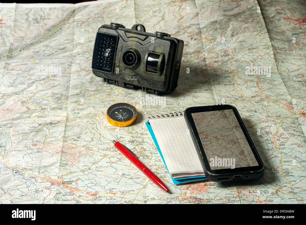 Trail camera and navigation tools on an exploration map Stock Photo