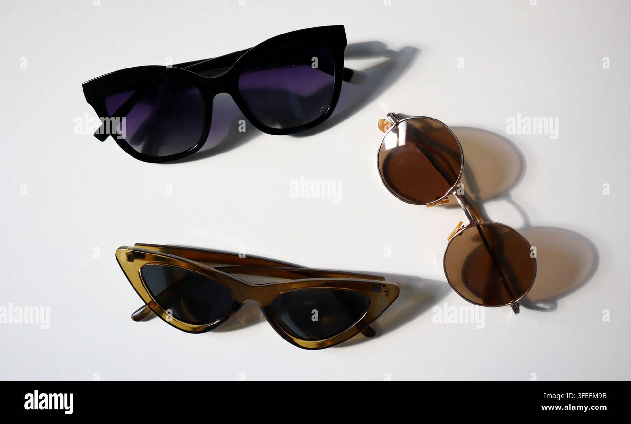 Three Pairs Of Sunglasses Are Placed On A Flat Surface In A Room With three-pairs-of-sunglasses-are-placed-on-a-flat-surface-in-a-room-with