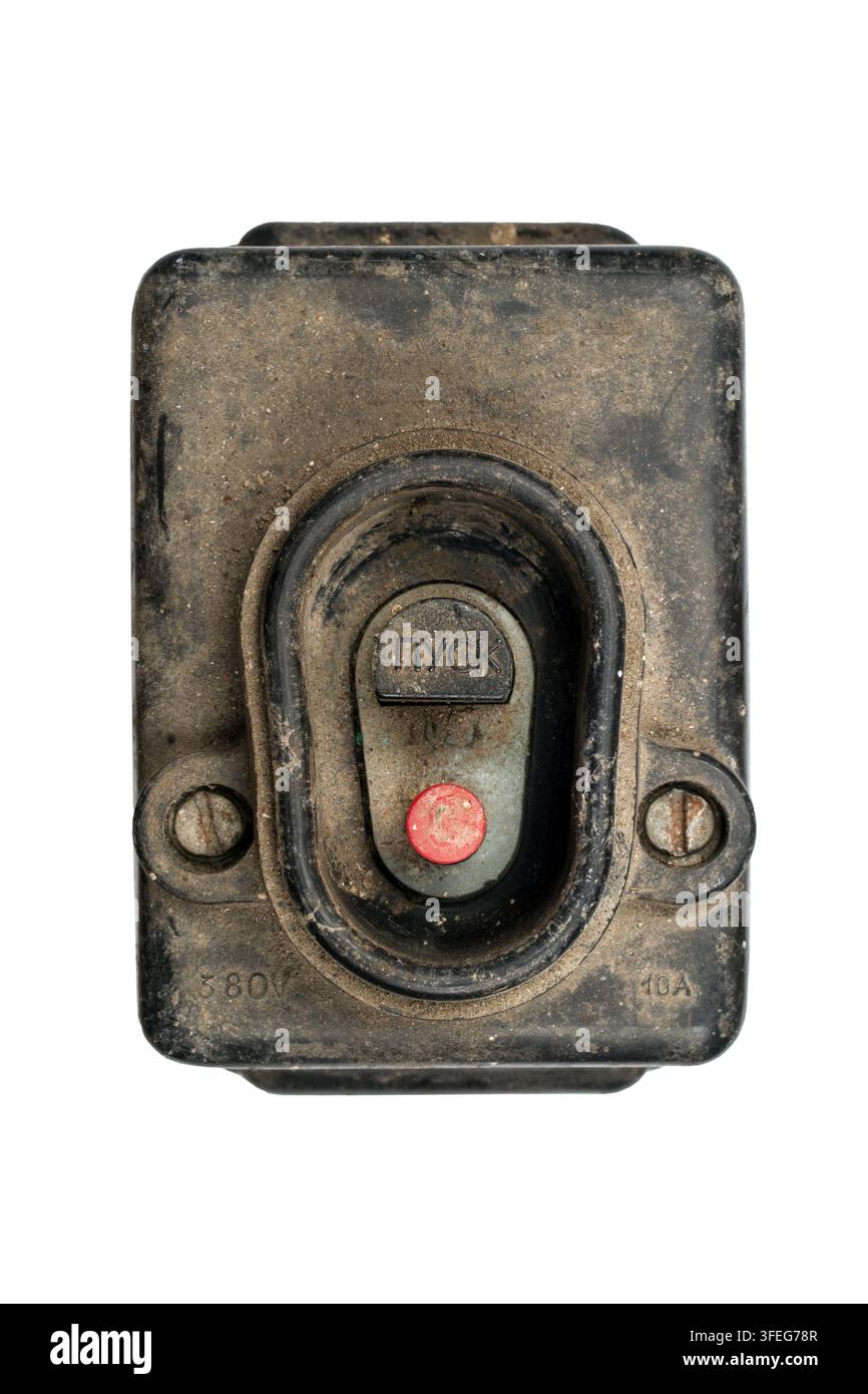 An old switch with a Start button. An old dirty switch on a white background. Powerful electrical switch. Stock Photo