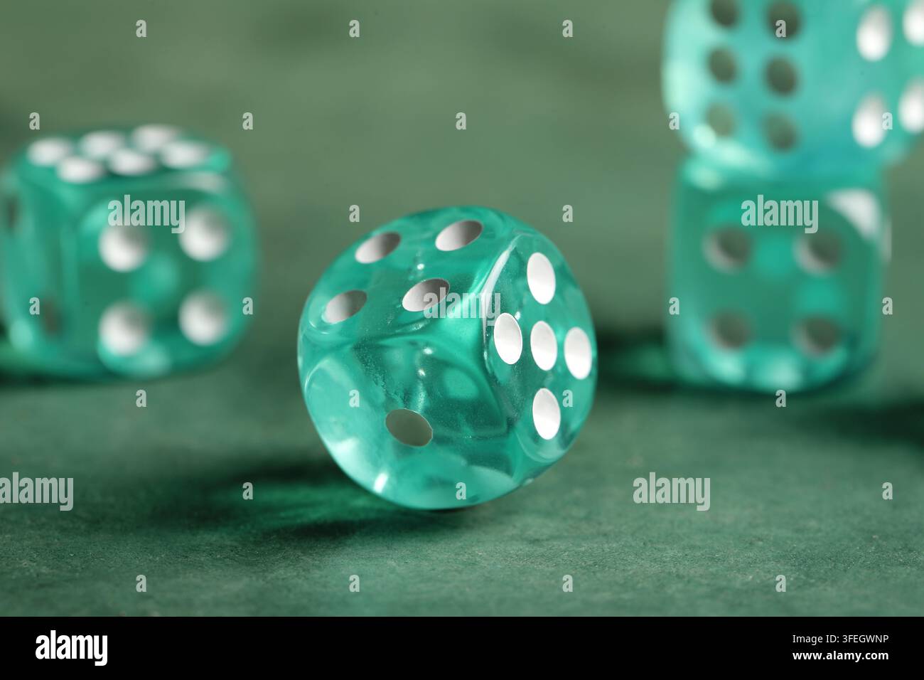 Turquoise game dices on green background Stock Photo