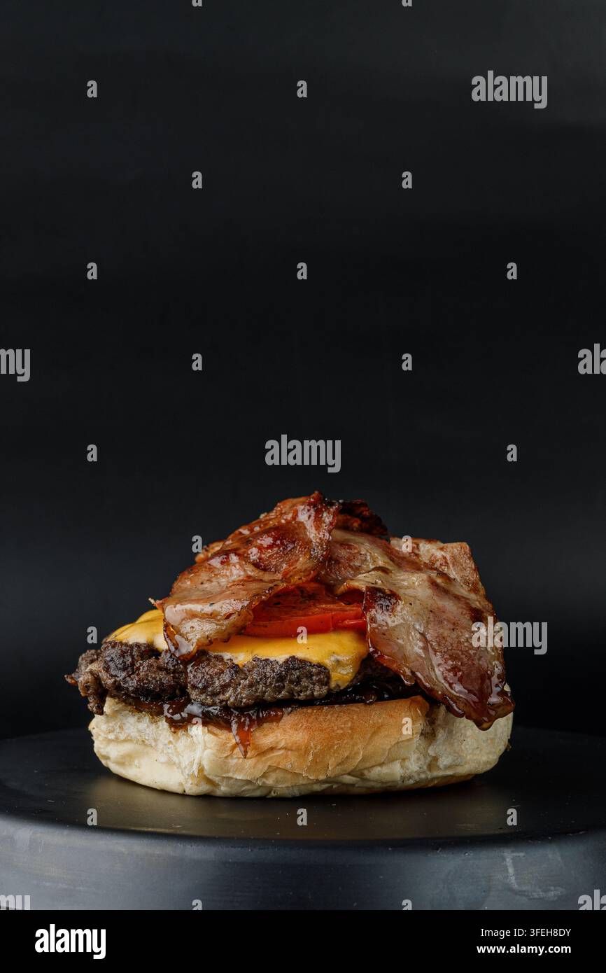 Delicious bacon cheeseburger on a dark plate Stock Photo