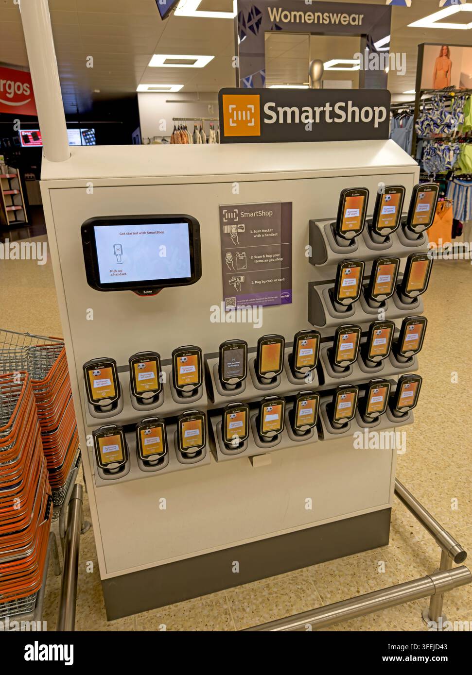 Sainsbury's SmartShop handheld scanners ready for customers inside a UK supermarket. Stock Photo