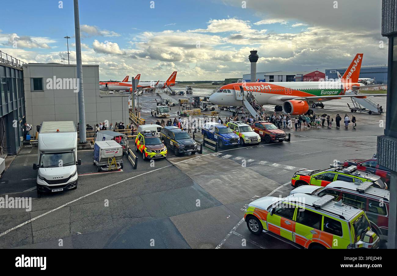 EasyJet aircraft and ground vehicles on the apron at Manchester Airport, England, UK. Stock Photo