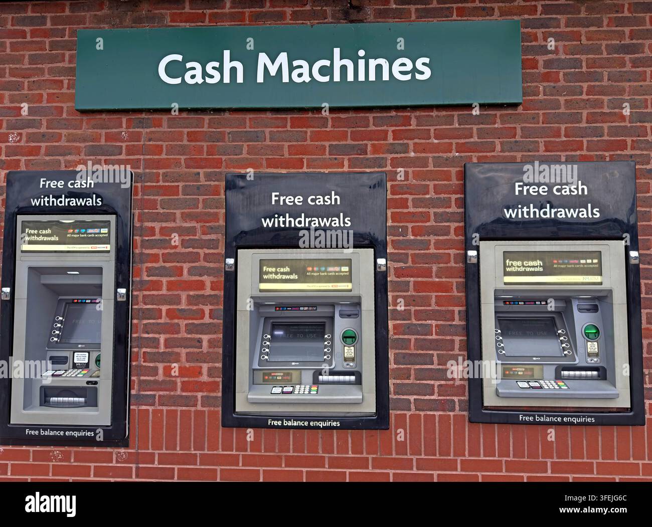 Three free-to-use UK cash machines installed together outside a supermarket, England, UK. Stock Photo