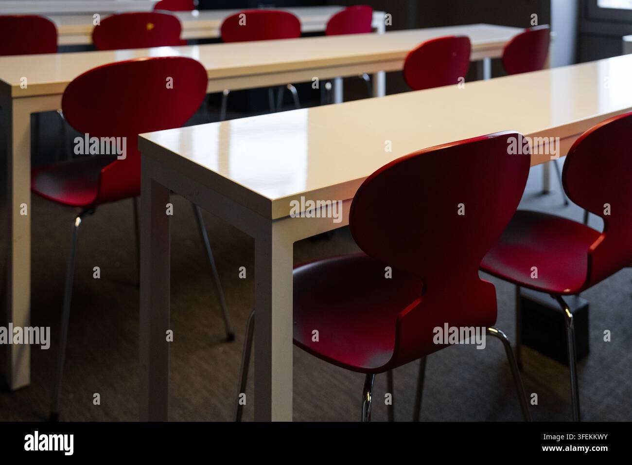 Empty red chairs and tables in modern classroom Stock Photo