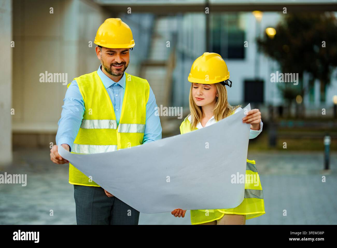 Engineers discussing blueprint for a construction project Stock Photo