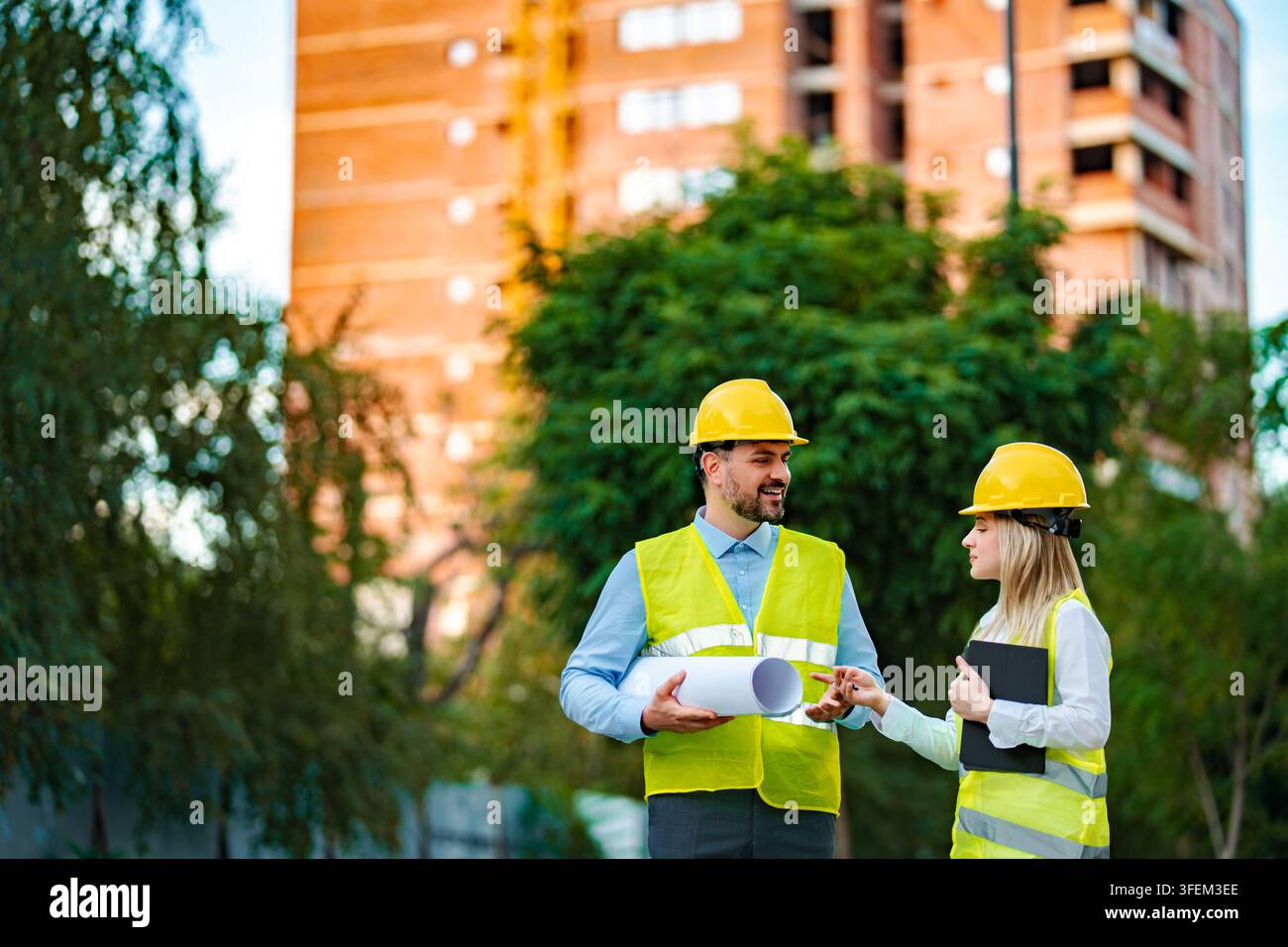 Engineers and architect discussing construction project outdoors Stock Photo