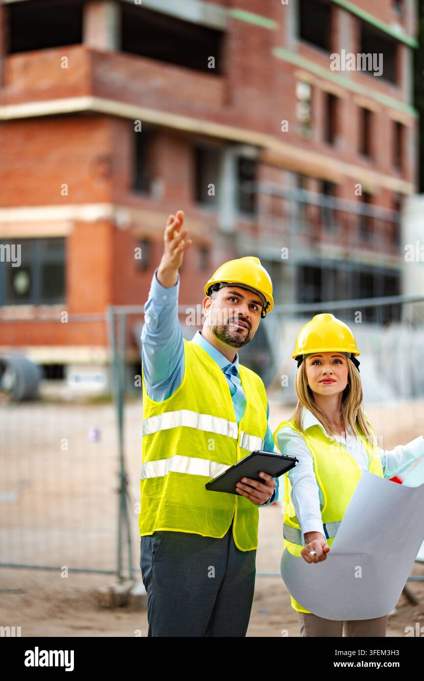 Construction engineers working on building site planning development Stock Photo