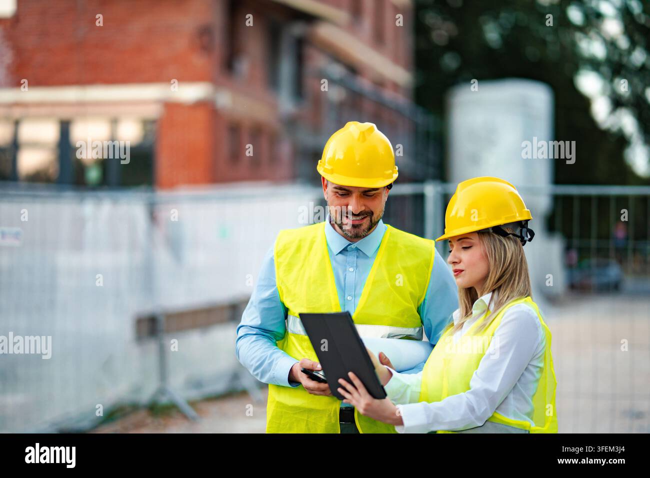 Architects using digital tablet at construction site Stock Photo