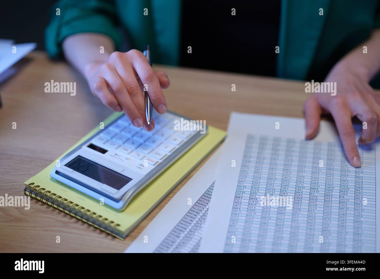 Accountant audits data in spreadsheet and counts on calculator Stock Photo