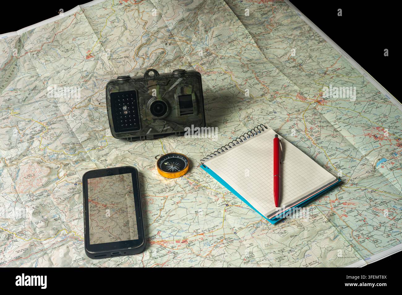 Trail camera scouting equipment on topographic map for exploration Stock Photo