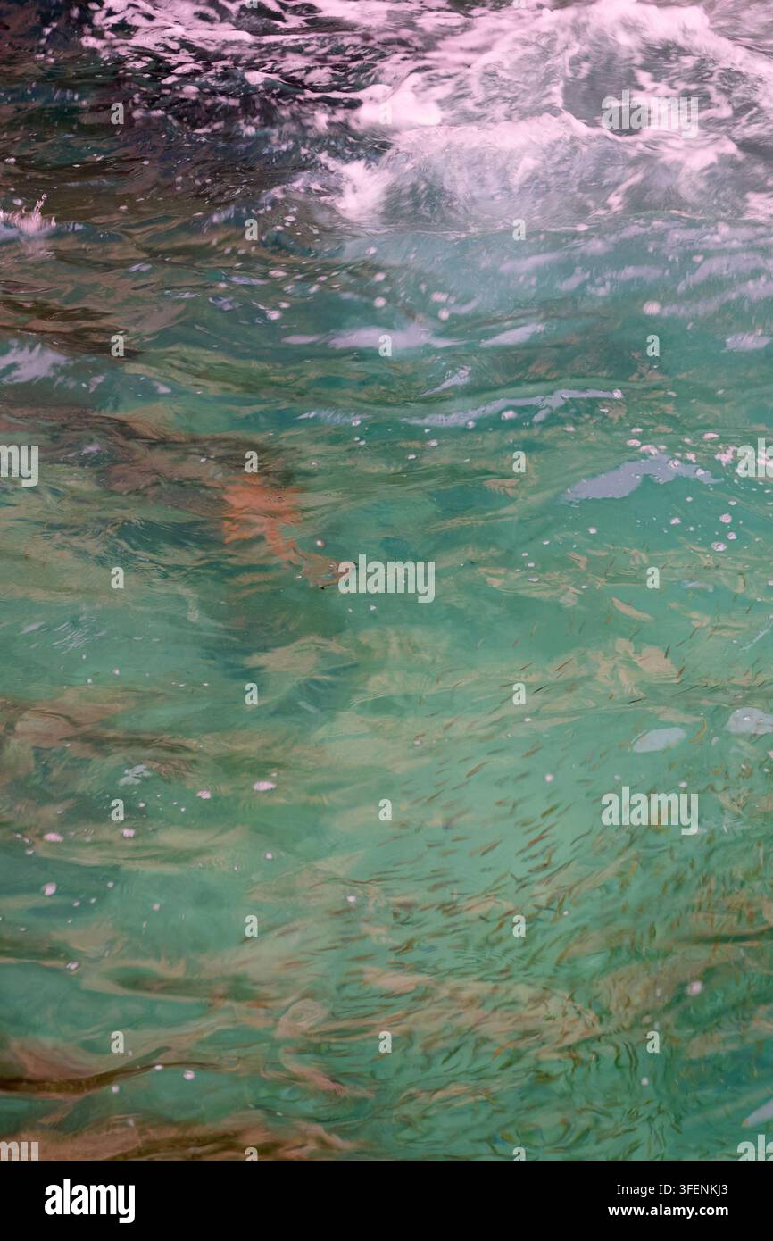 Crystal Clear Tropical Water Surface with Gentle Wave and Underwater Rock Texture Stock Photo