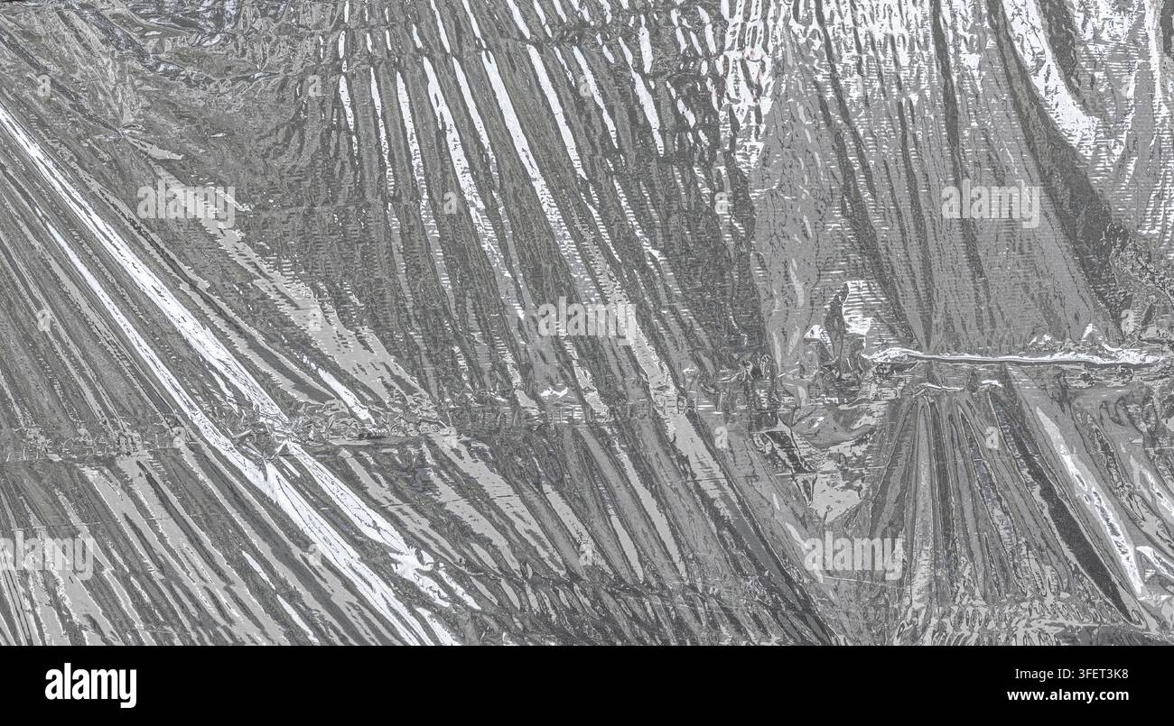 Crumpled silver metallic foil creating a textured, reflective surface Stock Photo