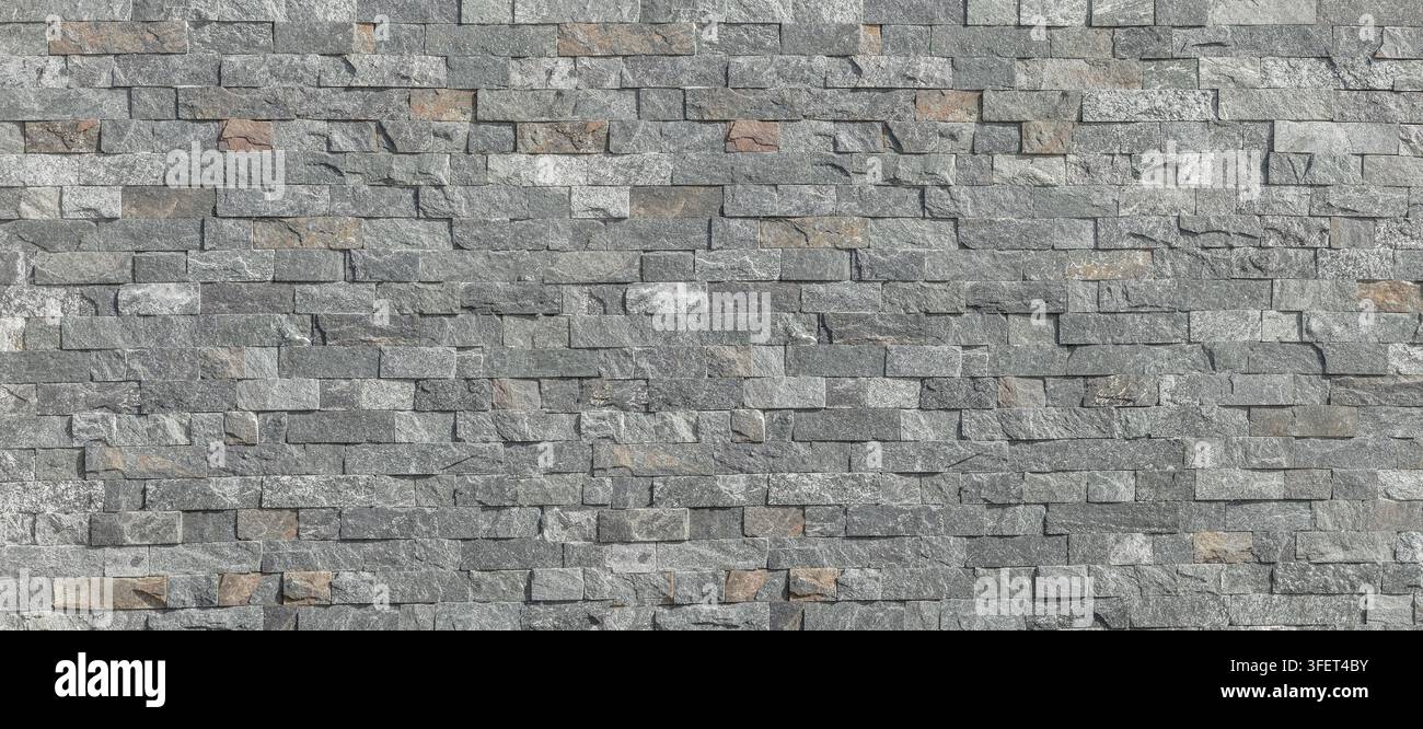 Layered grey slate stone wall presenting a rustic surface texture Stock Photo