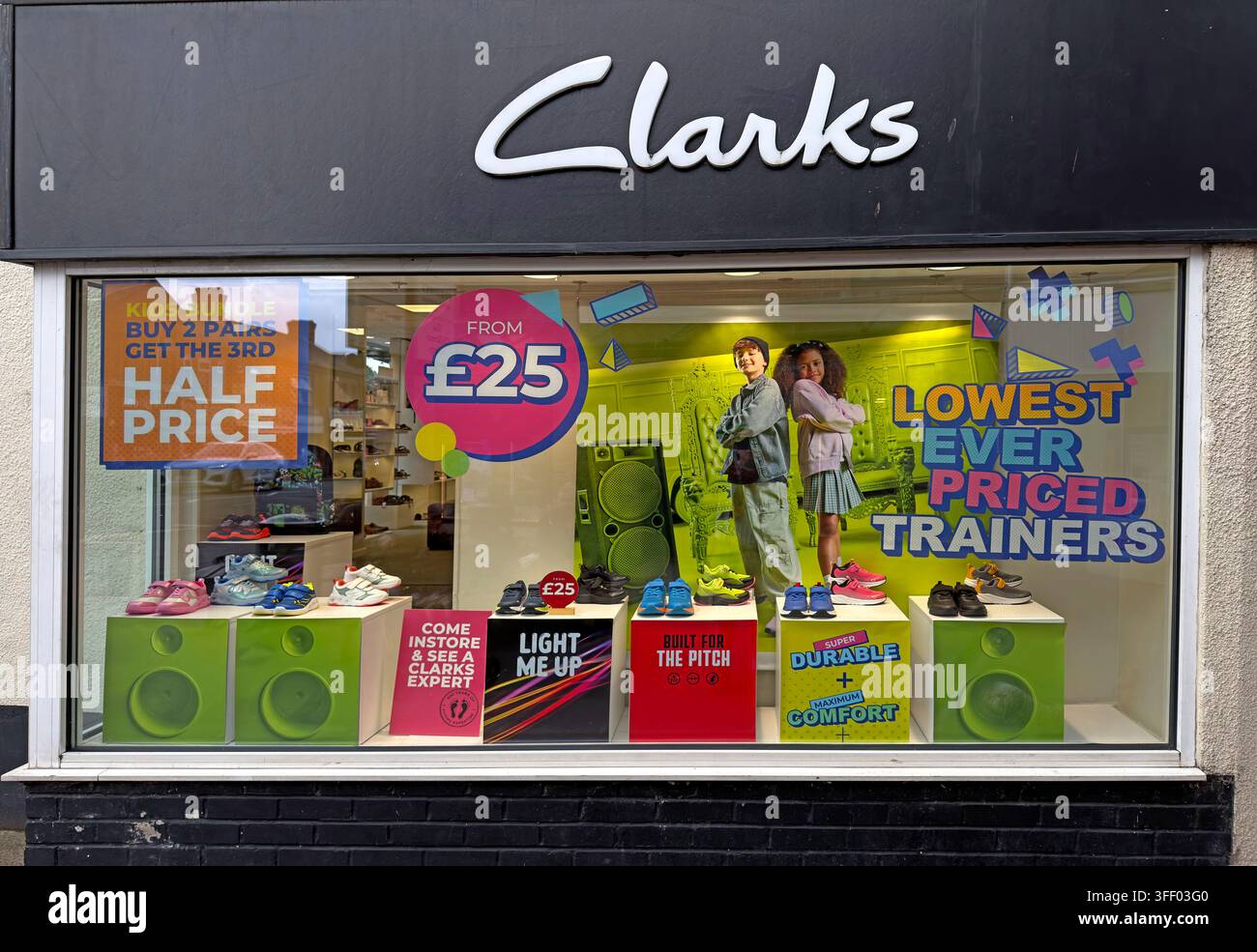 Clarks shoe shop in Stockton Heath, Warrington, advertising half-price and 'lowest ever priced' trainers during a retail sale. Stock Photo
