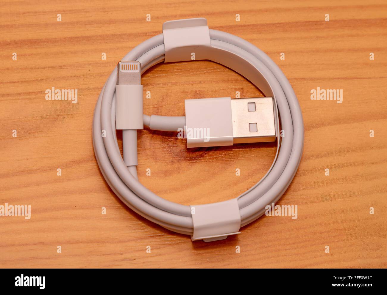 Apple USB to lightning connector cable on wooden table Stock Photo