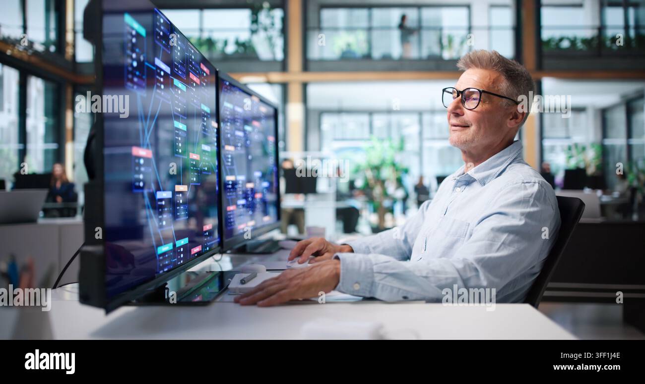 Business Analyst Reviews Low Code Platform Workflow On Desktop Computer. Stock Photo