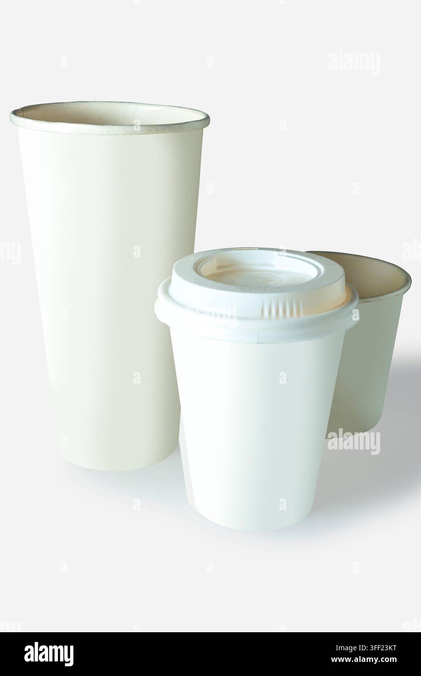 Three white and beige paper coffee cups in various sizes, one with a lid, isolated on a white background. Mockup or Copyspace Stock Photo