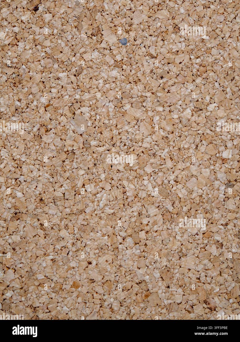 Close up natural light brown corkboard surface showing granular recycled fiber texture, warm rustic backdrop ideal for backgrounds, design elements, a Stock Photo