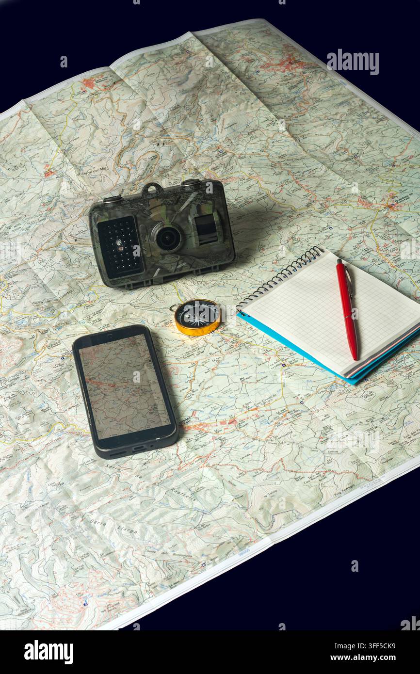 Navigating wilderness with map, camera, smartphone, and compass Stock Photo