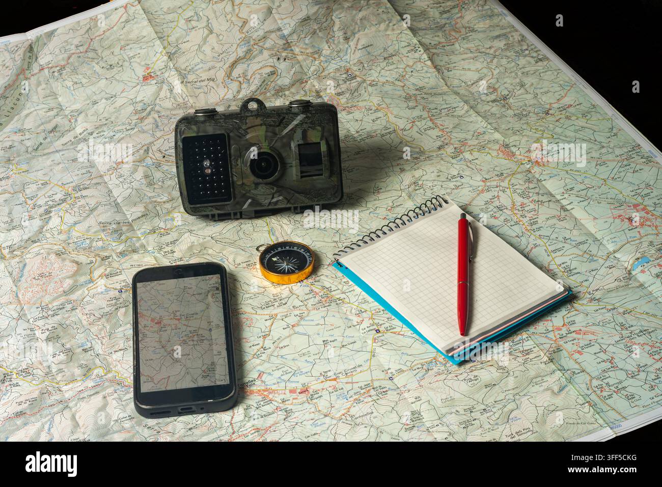 Planning outdoor adventure using map, compass, trail camera Stock Photo