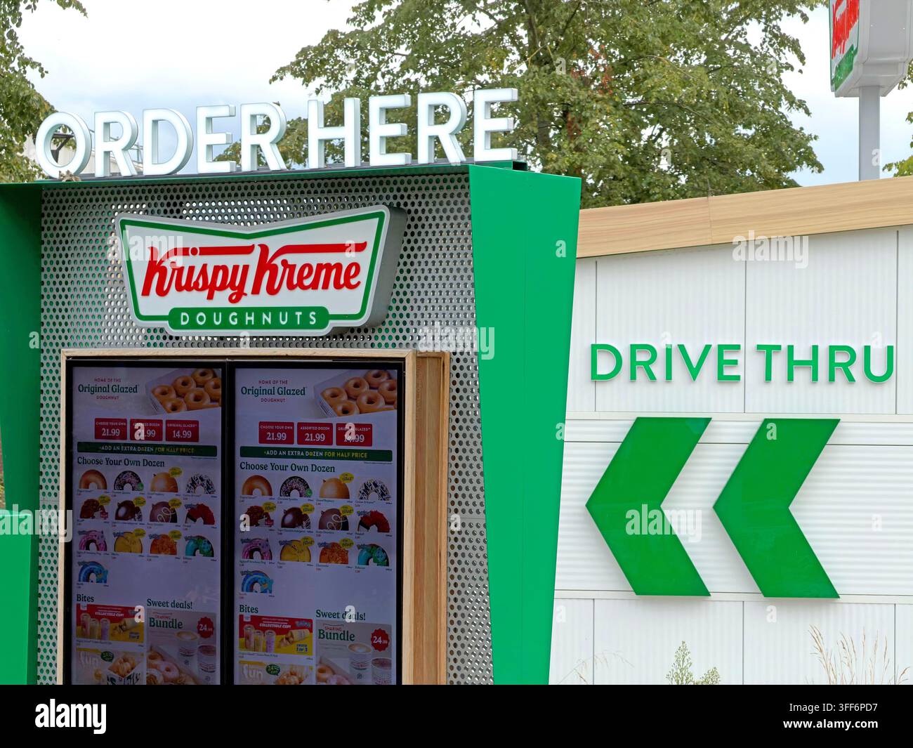 Krispy Kreme drive-thru order point in Warrington, combining doughnut retail with the car-based fast-food service model. Stock Photo