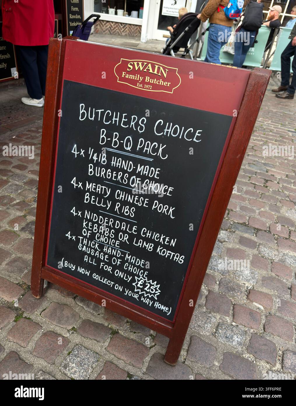 Swain Family Butchers A-board in York city centre advertising barbecue meat offers, linking a traditional butcher with seasonal outdoor cooking. Stock Photo