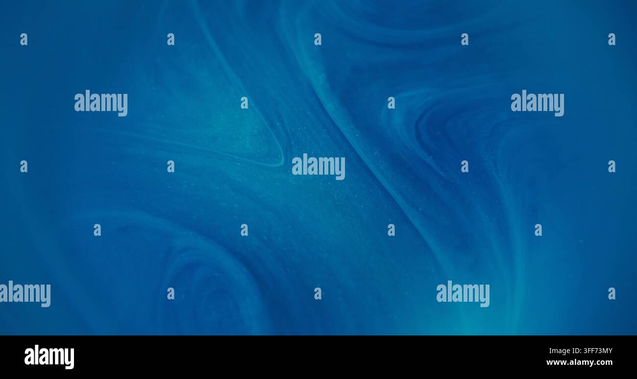 Defocused glitter paint. Blue splash pigment. Vibrant color bright texture water particles fluid spill on abstract art background. Stock Photo