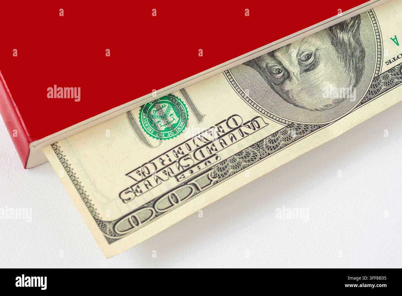 Hundred Dollar Bill Hidden in Red Book. One hundred dollar banknote ...