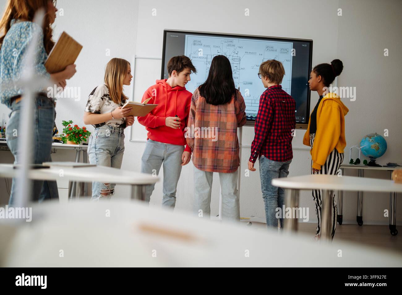 High school students collaborating on engineering project using interactive display. Stock Photo