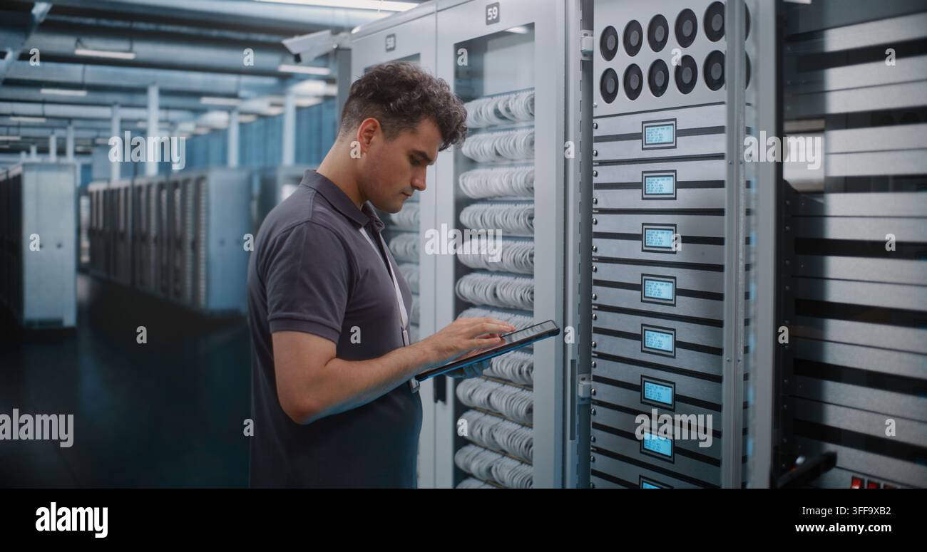IT Engineer Holds Digital Tablet while Touching and Inspecting Server Rack Modules in Modern Data Center. Routine Hardware Maintenance, Physical Checks Ensure High Availability Server Infrastructure. Stock Photo