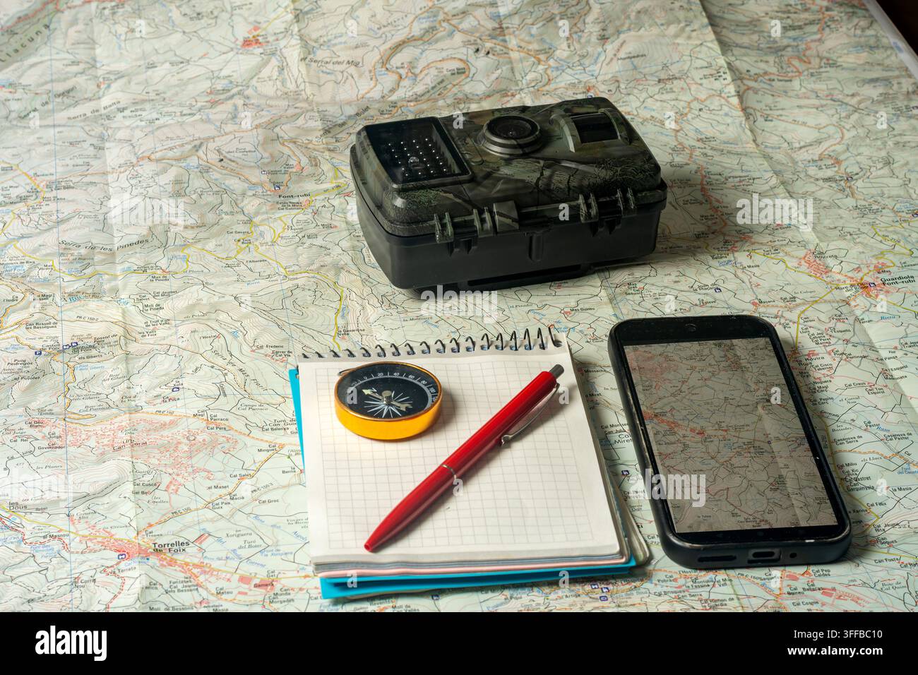 Wildlife trail camera and navigation tools on map Stock Photo