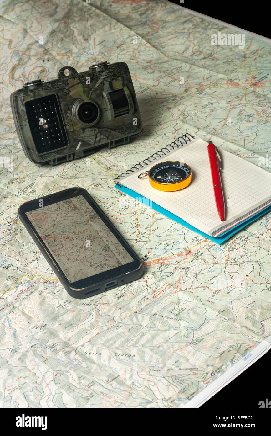 Planning wilderness exploration using trail camera, map, compass Stock Photo