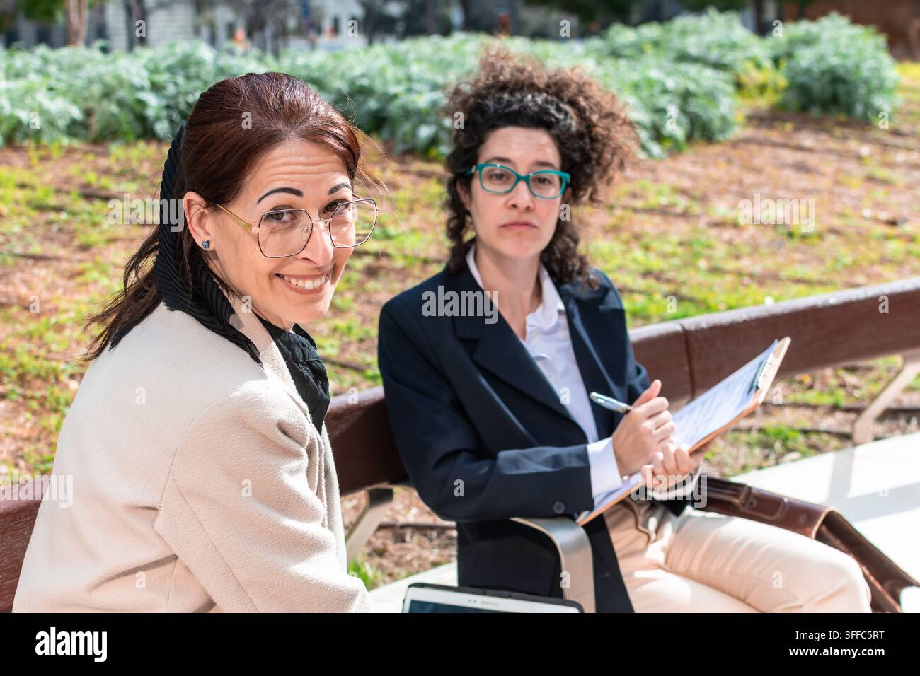 Business women collaborating outdoors during informal meeting Stock Photo