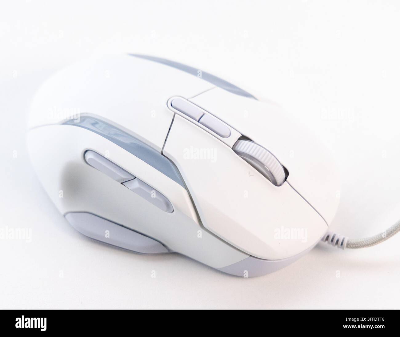 A sleek white wired gaming mouse is on a clean white surface Stock Photo
