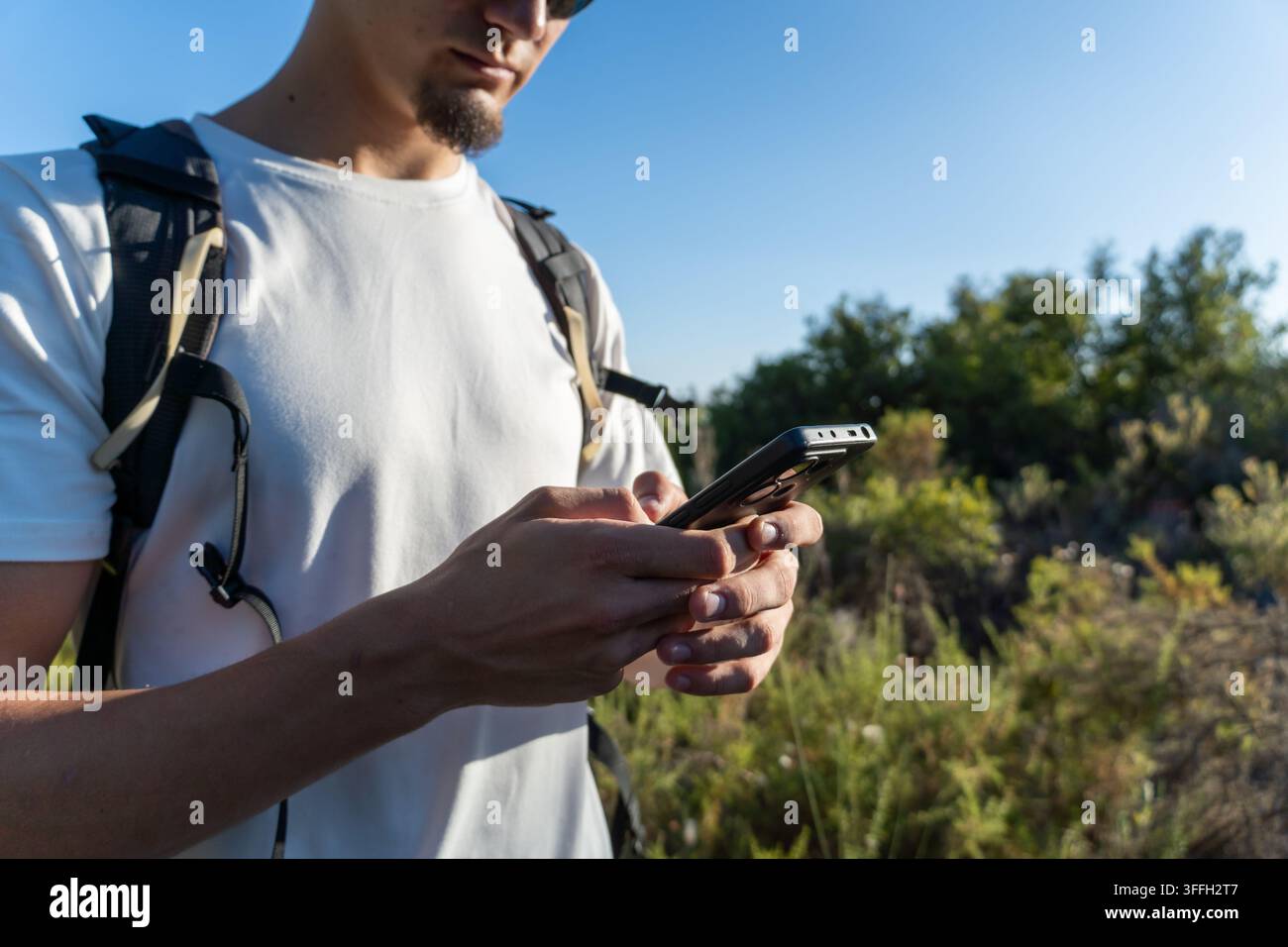 Man using smartphone for navigation during hiking Stock Photo