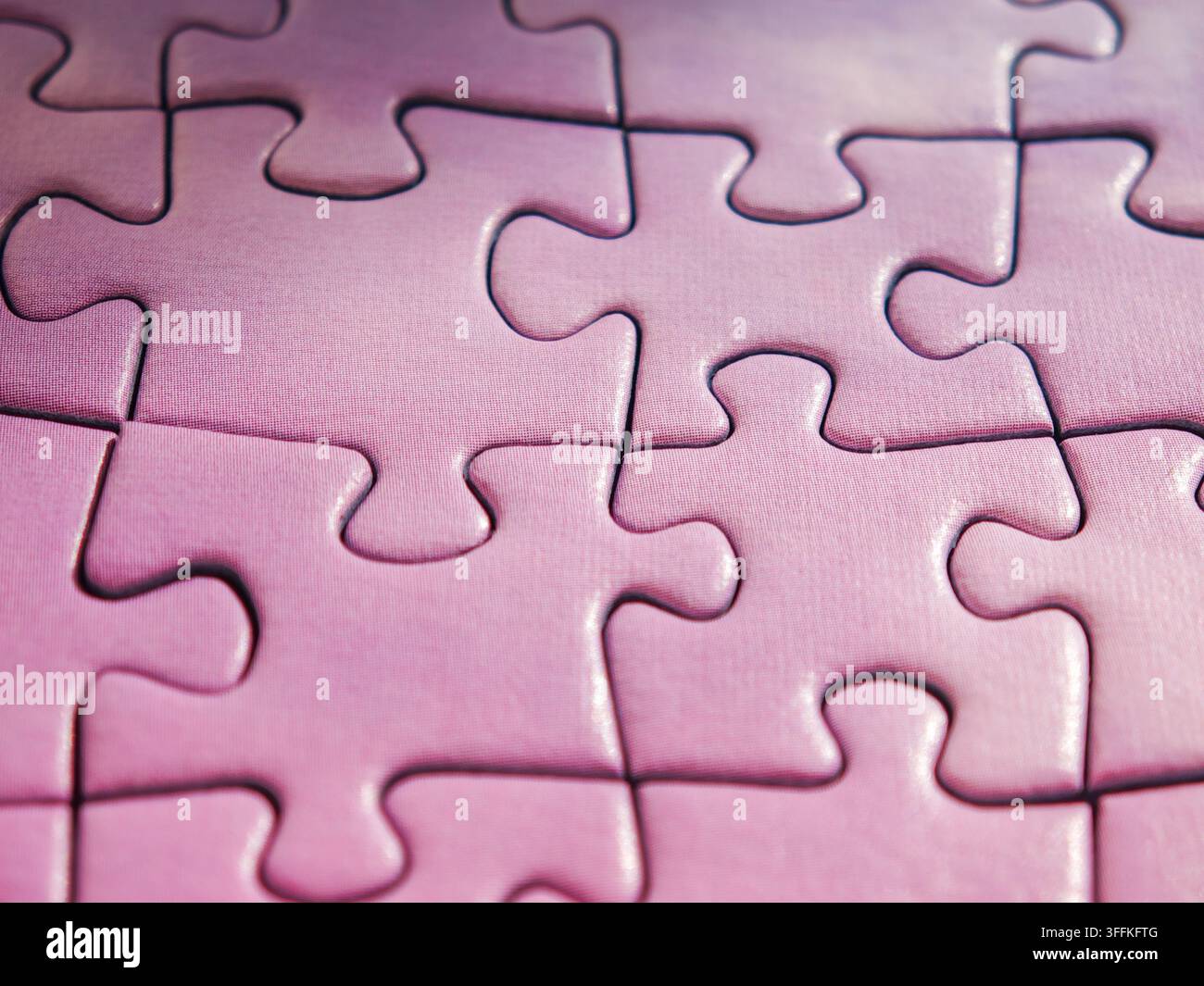 Purple jigsaw puzzle with last missing piece being placed into hole Stock Photo