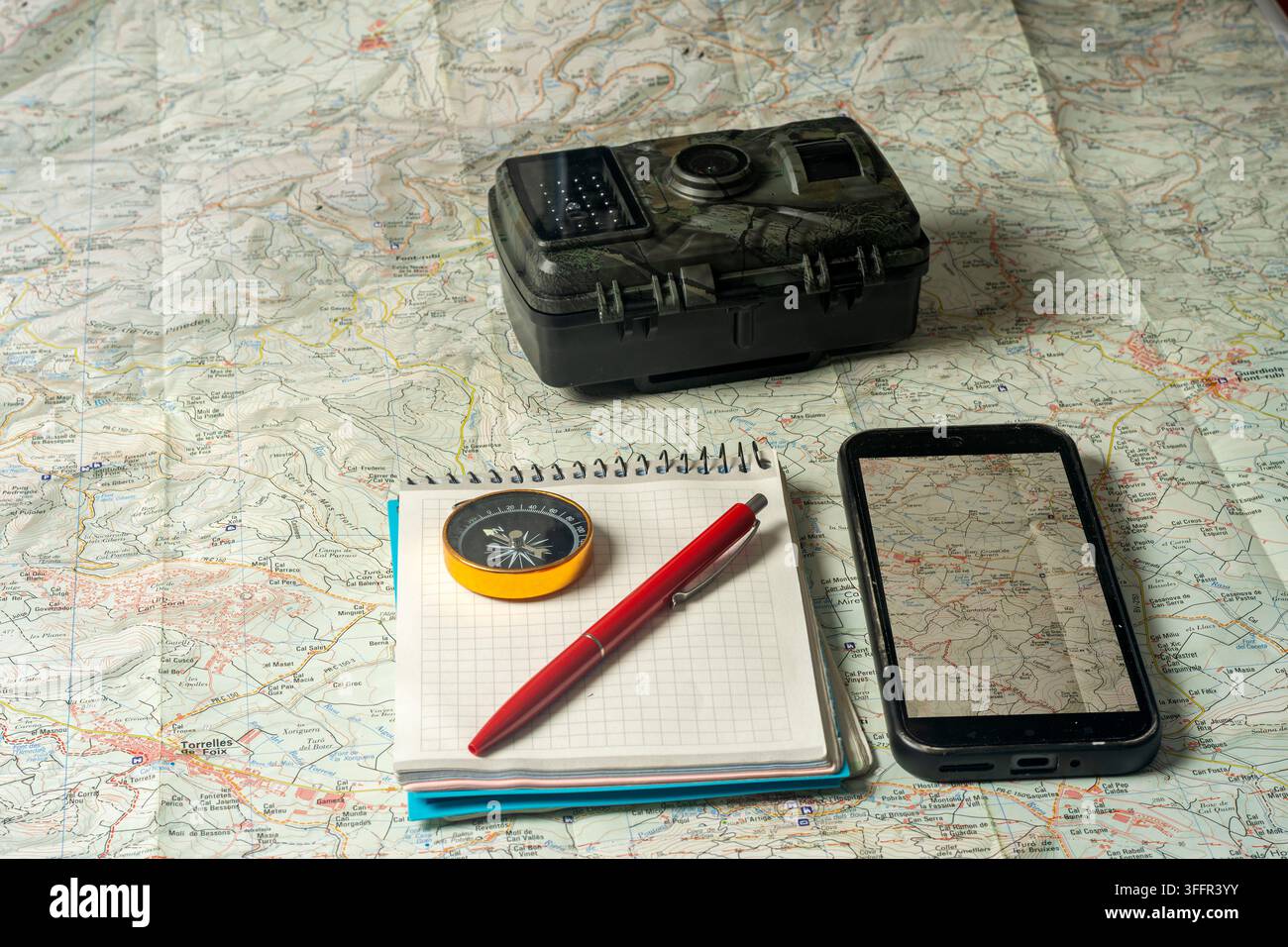 Planning outdoor adventure using map, compass, and technology Stock Photo