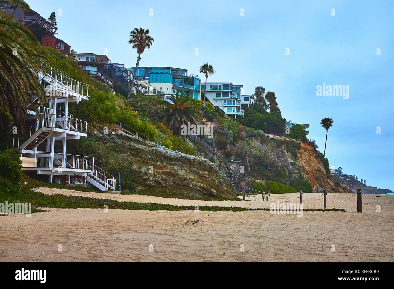 Laguna Beach Cliffside Homes Palm Trees and Sandy Shore at Thousand Steps Beach Stock Photo