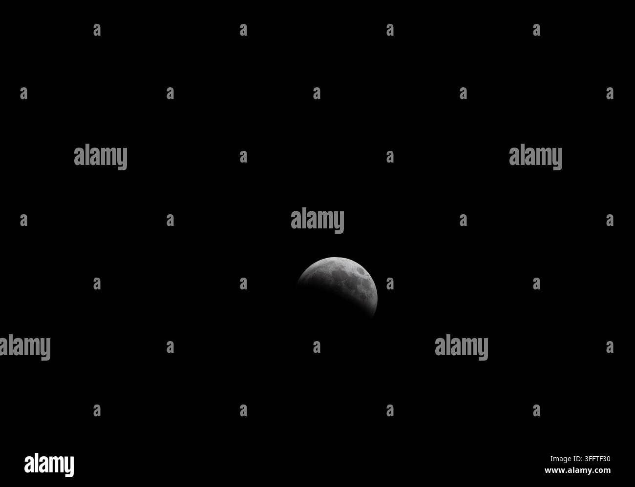 Lunar eclipse: the Earth casting its shadow on the Moon, viewed from the Amazon Rainforest in Brazil Stock Photo
